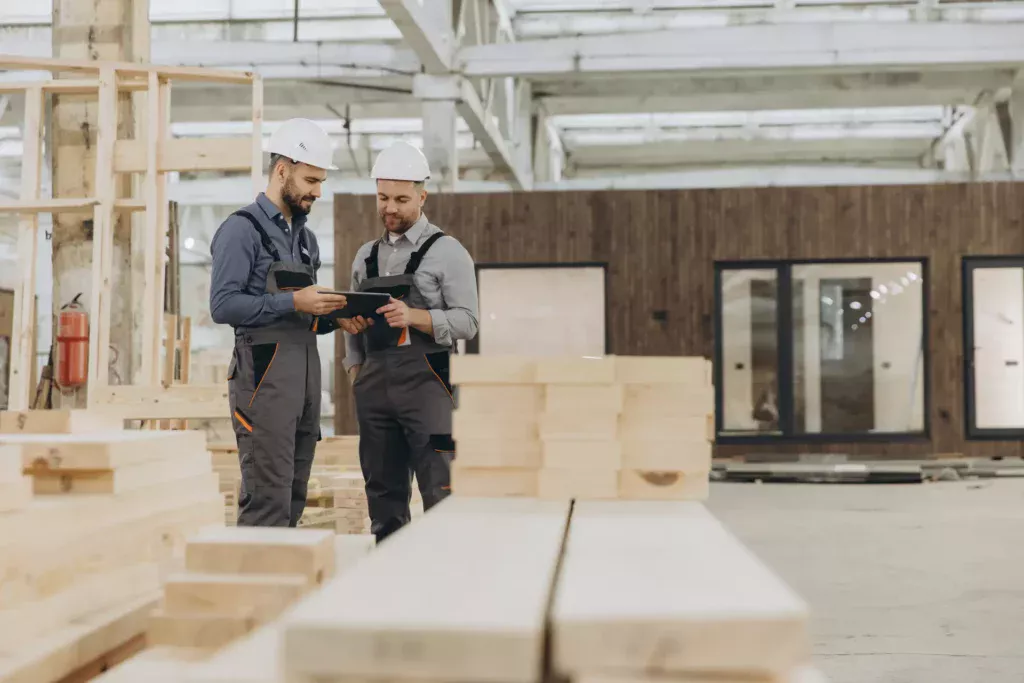 Ouvriers travaillant sur des modules préfabriqués dans un hangar de réparation pour le réemploi de bâtiments modulaires