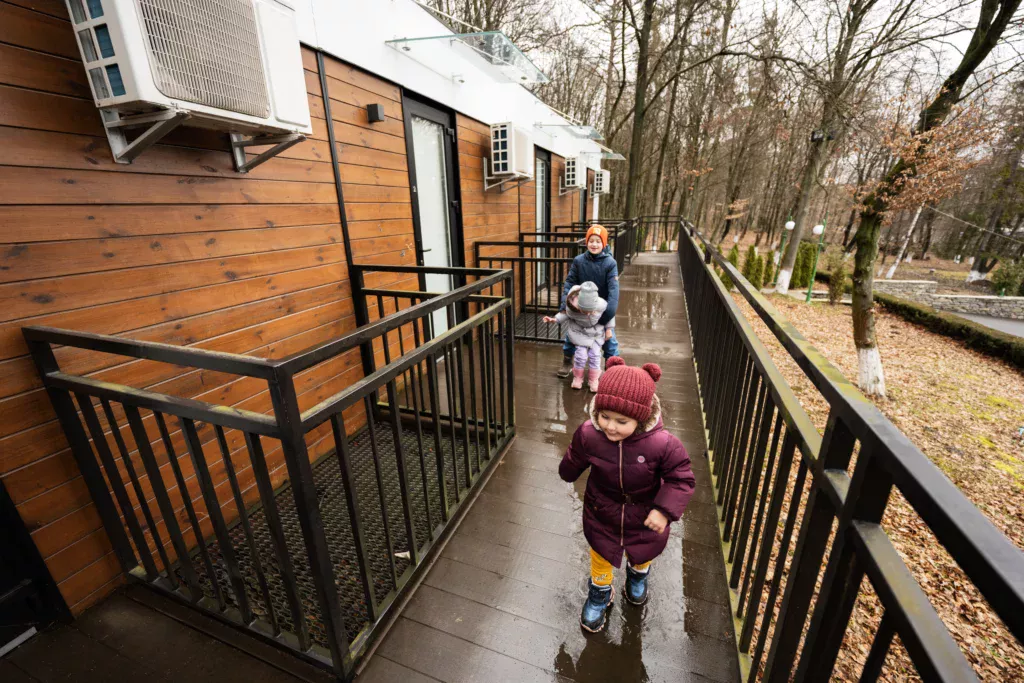Réemploi bâtiment modulaire résidentiels en réemploi installés en forêt, avec des enfants courant devant