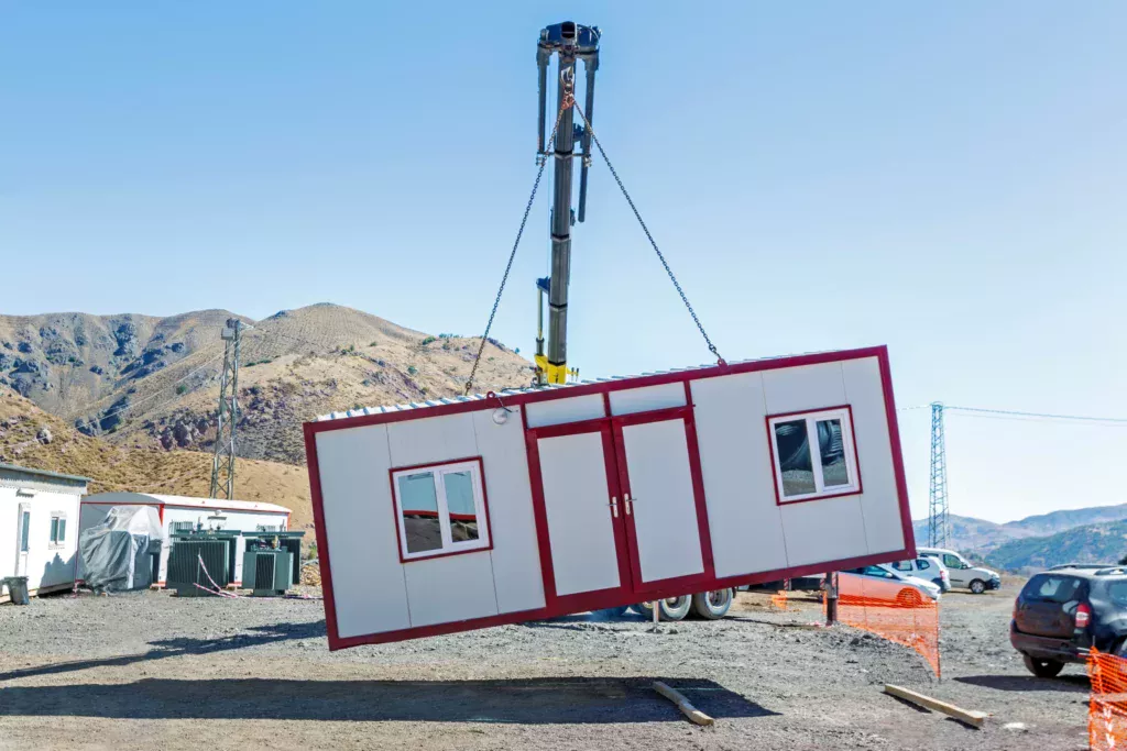 Phase de soulèvement du réemploi de bâtiments modulaires sur un chantier à l'aide d'une grue