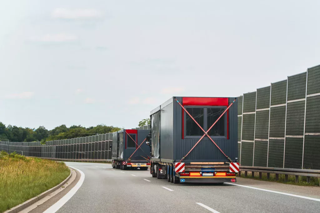 Camions transportant des modules préfabriqués sur une autoroute dans le cadre de réemploi de bâtiments modulaires