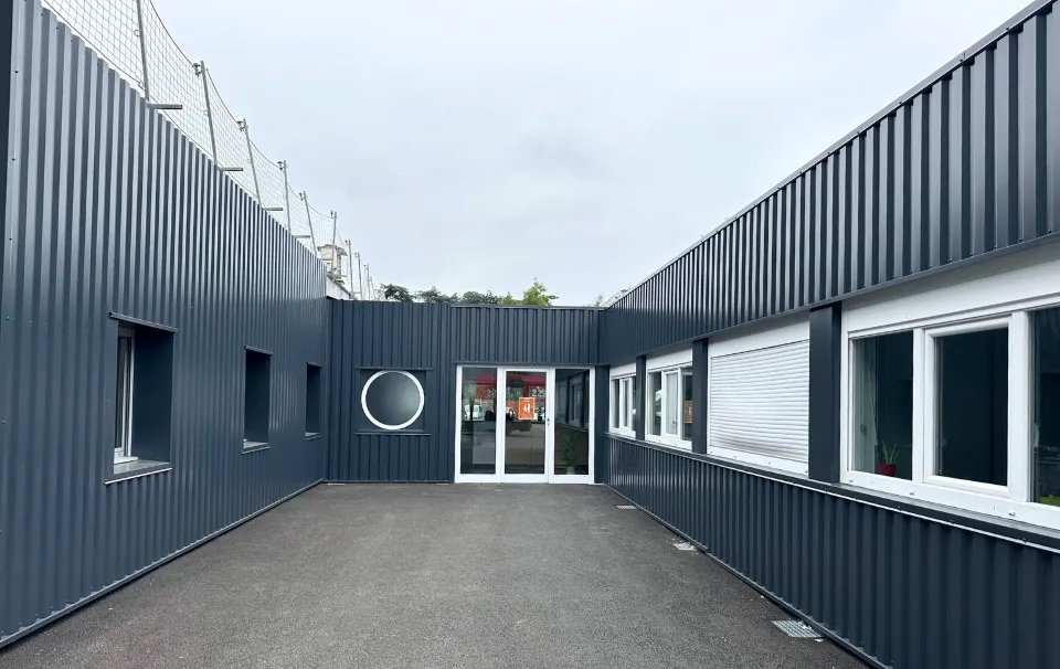 façade peinte en noir d'un bâtiment modulaire peint en noir avec de la menuiserie blanche